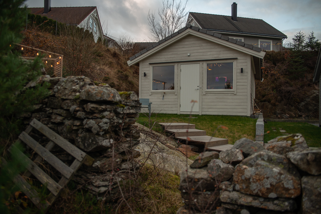 Det hvite studiohuset bak en gammel steinmur